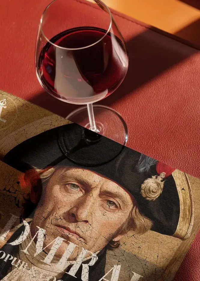 The Admiral brand collateral on a table with a glass of wine